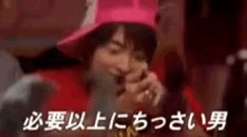 a man wearing a pink hat and a red shirt is laughing in a crowd .