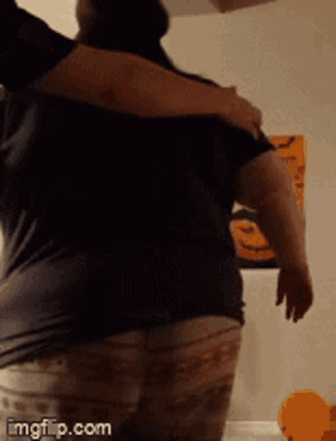 a man is hugging another man in front of a wall with halloween decorations