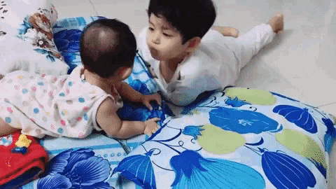 a boy and a baby are laying on a bed .