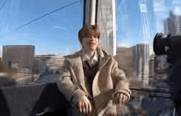 a man is sitting on a chair in front of a glass window .