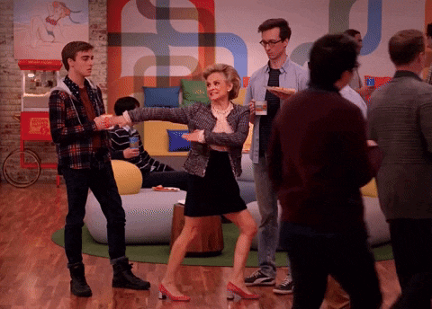 a woman dancing in a room with a popcorn machine behind her