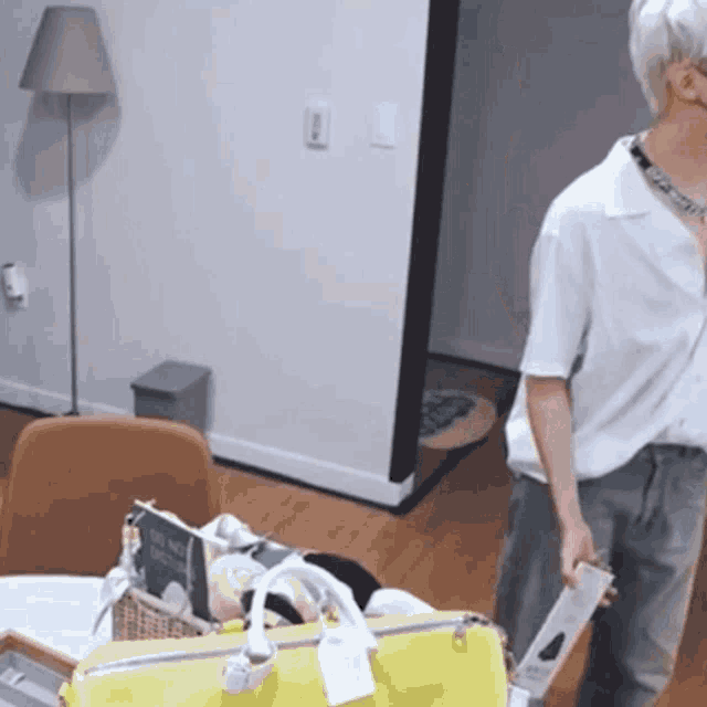 a man in a white shirt is holding a yellow bag