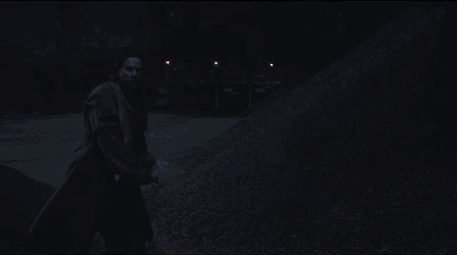 a man in a robe is holding a blue lightsaber