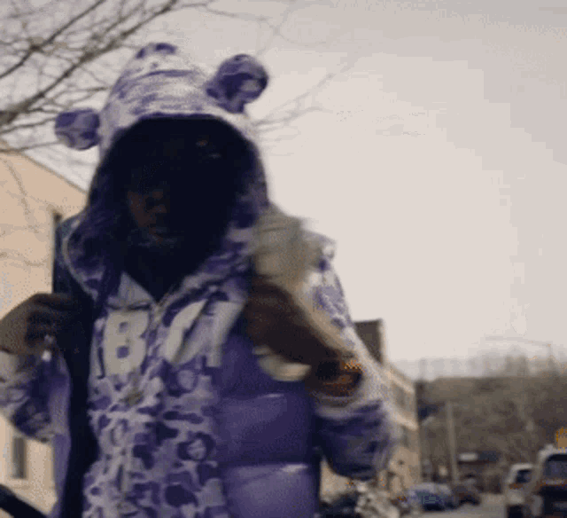 a person wearing a purple jacket with the number 18 on the front
