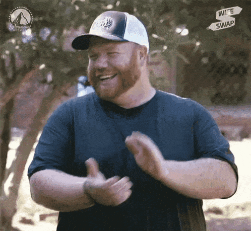 a man wearing a hat that says wife swap is clapping his hands