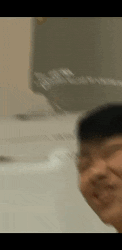 a blurry picture of a man making a funny face in front of a washing machine .