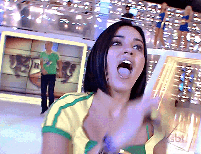 a woman wearing a yellow and green shirt with the word sbk on the front