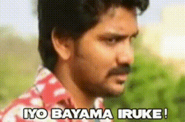 a man with a mustache is wearing a red and white shirt and says iyo bayama iruke