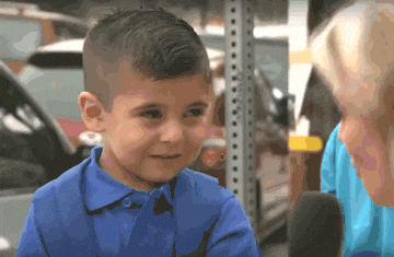a young boy wearing a blue nike polo shirt