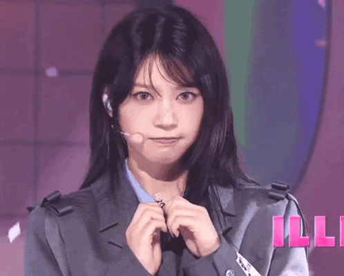 a woman wearing a microphone and a jacket with the word ille in the background