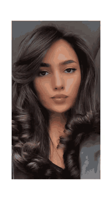 a woman with long dark hair is wearing a black jacket