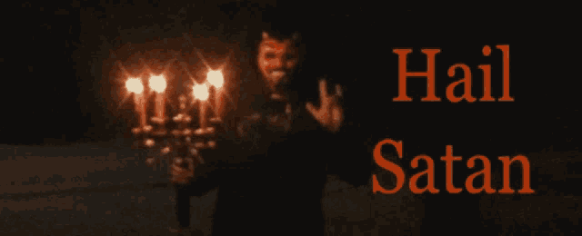 a man with horns on his head is holding a candelabra with the words hail satan written above him