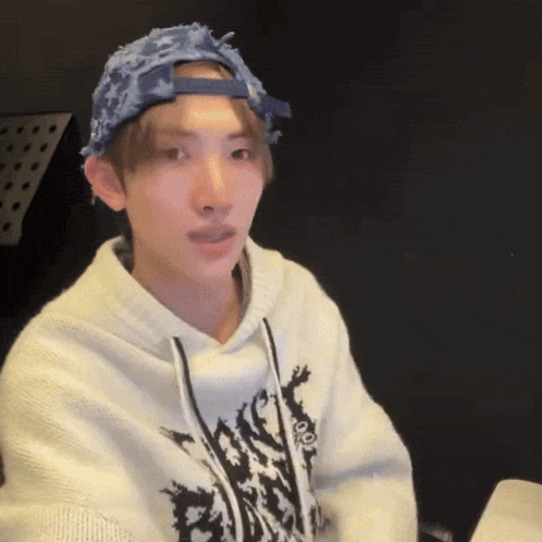 a young man wearing a hat and a hoodie with the word peace on it