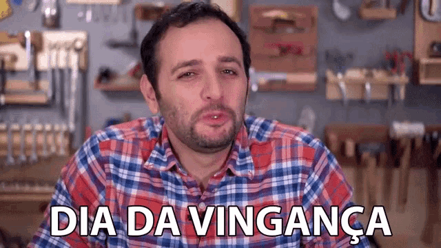 a man in a plaid shirt says dia da vinganca in front of a wall of tools .