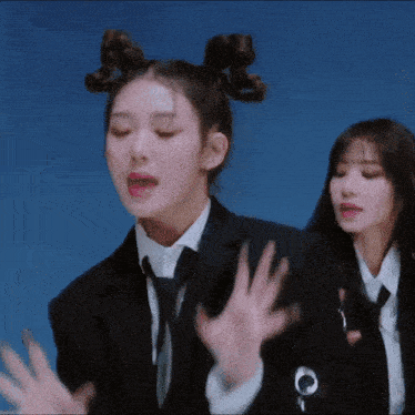 a woman in a suit and tie is dancing with another woman in a white shirt .
