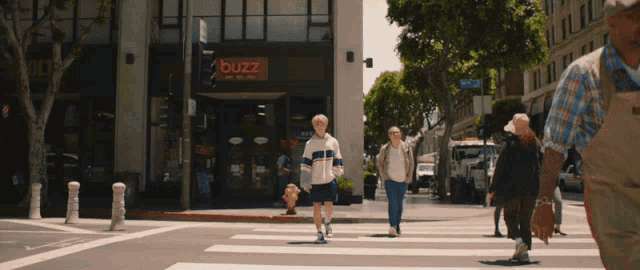 people crossing a street in front of a buzz cafe