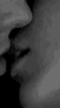 a black and white photo of a man 's face with a tie on .