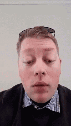 a man wearing sunglasses and a plaid shirt is looking at the camera