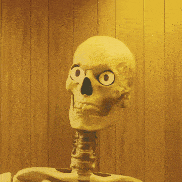 a skeleton with googly eyes is standing in front of a wood paneled wall