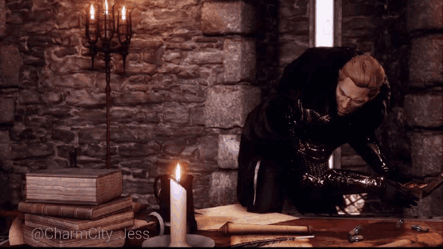 a man is kneeling down in front of a table with candles and books and the words charm city jess on the bottom right