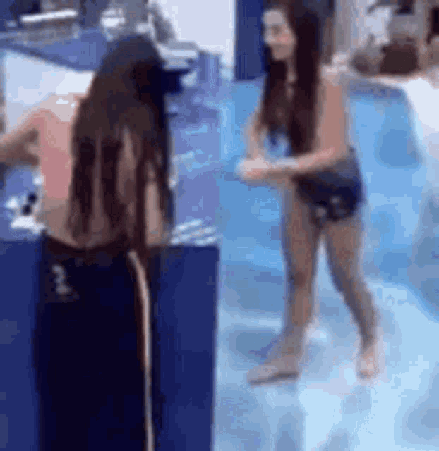 a couple of women are standing next to each other in a pool .
