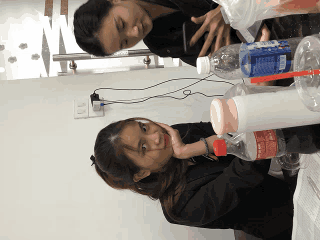 a bottle of pepsi sits on a table with two women