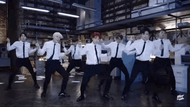 a group of men in ties are dancing in an office