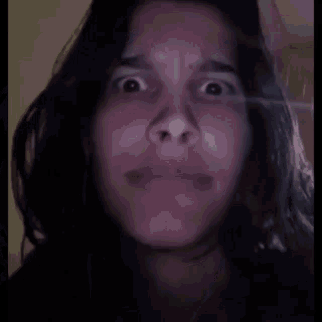 a close up of a woman 's face with a shocked expression