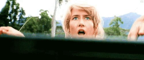a woman is looking out of the window of a car with her mouth open .