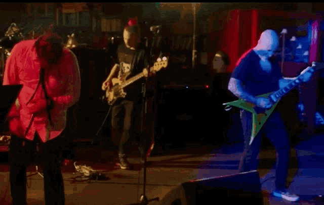 a man in a red shirt playing a guitar