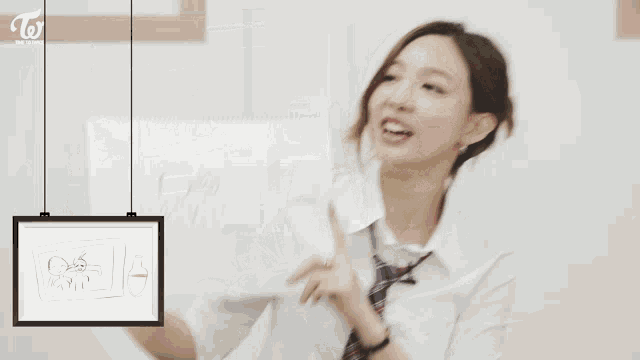 a girl with a plaid headband is sitting in front of a chalkboard that says dahyun