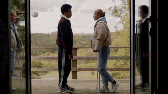 a boy and a girl standing next to each other on a porch