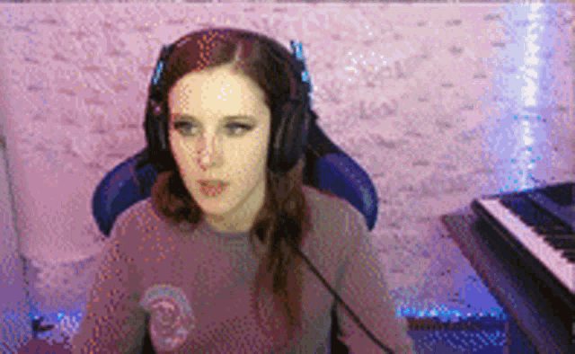 a woman wearing headphones sitting in front of a piano .