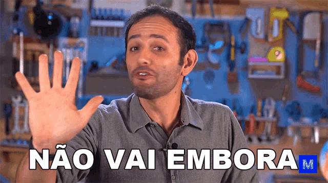 a man says não vai embora m in front of a tool wall