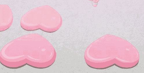 a pink heart shaped object is being decorated with icing