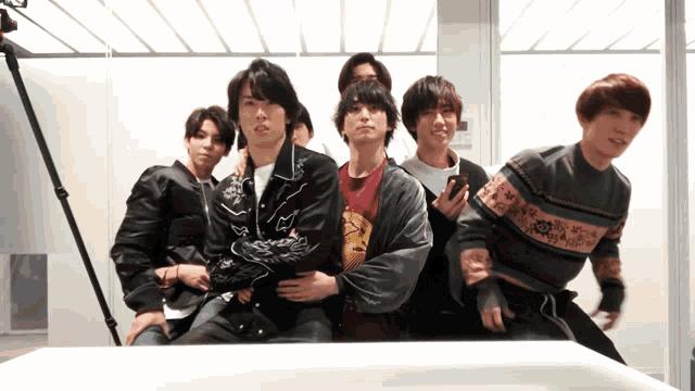 a group of young men are posing for a picture in front of a mirror