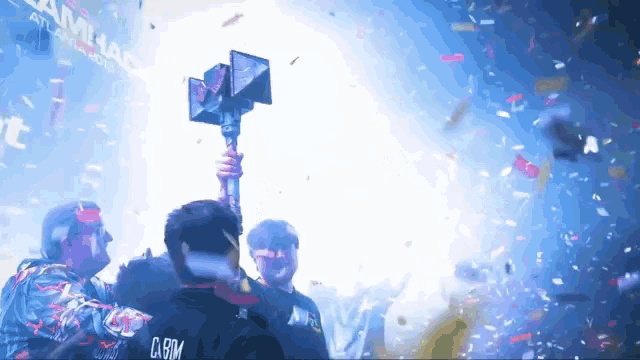 a man holding a trophy with the word carim on the back of his shirt