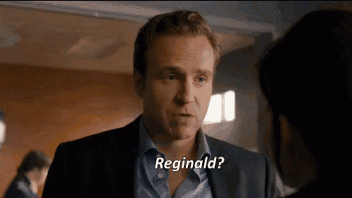 a man in a suit and blue shirt is talking to a woman and says reginald ?