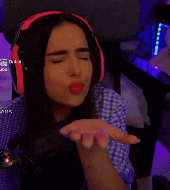 a woman wearing headphones is making a funny face with the words dubai in the corner