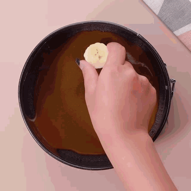 a person is putting a slice of banana in a bowl