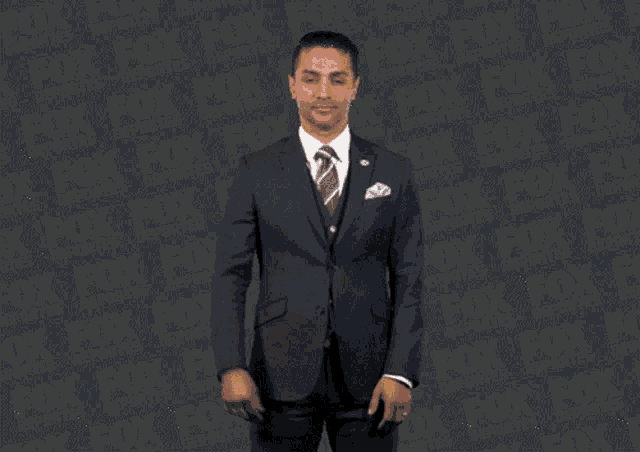 a man in a suit and tie stands in front of a fox logo