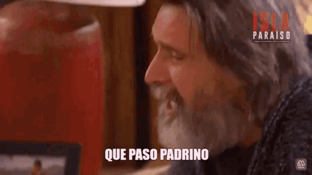a man with a beard is crying and the words que paso padrino are on the screen behind him .