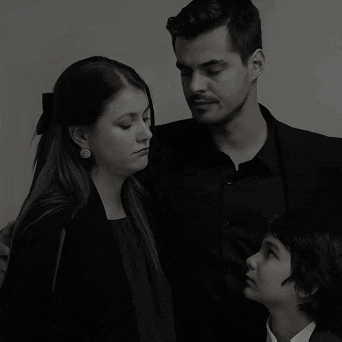 a black and white photo of a man a woman and child