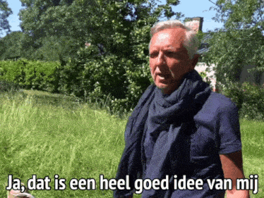 a man with a scarf around his neck is standing in a grassy field with the words ja dat is een heel goed idee van mij below him