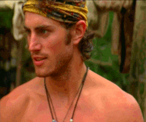 a shirtless man wearing a yellow headband and a necklace