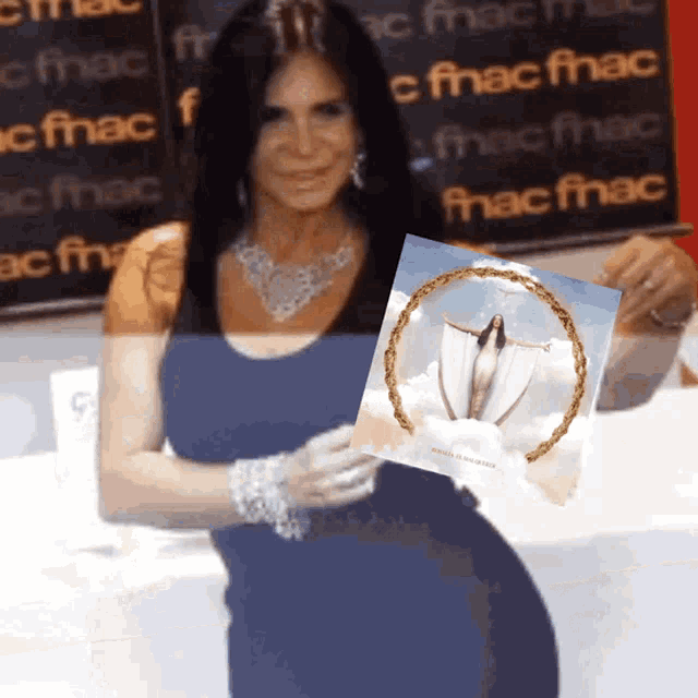 a woman in a blue dress holds a picture of a woman in a circle