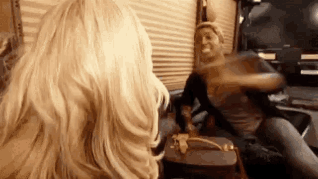 a woman is sitting in a chair with a purse and a man is sitting in a chair .