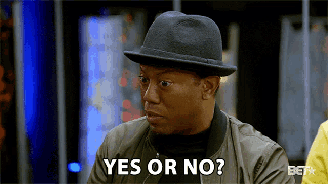 a man wearing a hat and a bomber jacket says yes or no