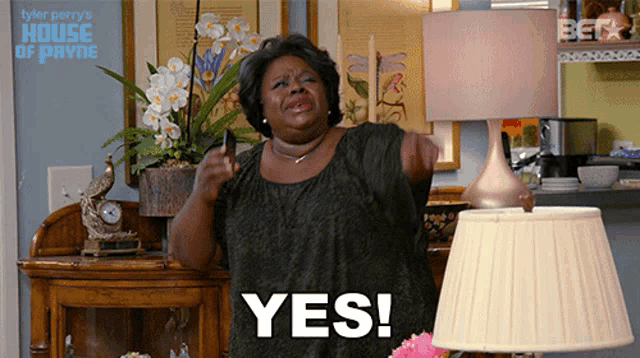 a woman says yes in front of a house of payne poster