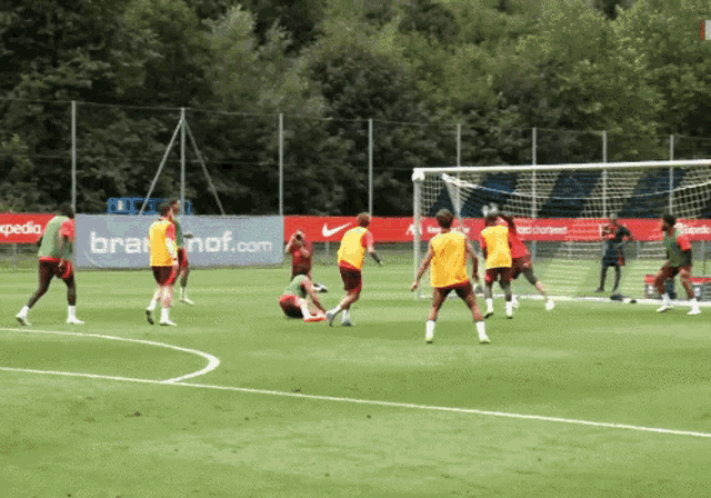 a group of soccer players are playing on a field with an advertisement for brafnof.com in the background